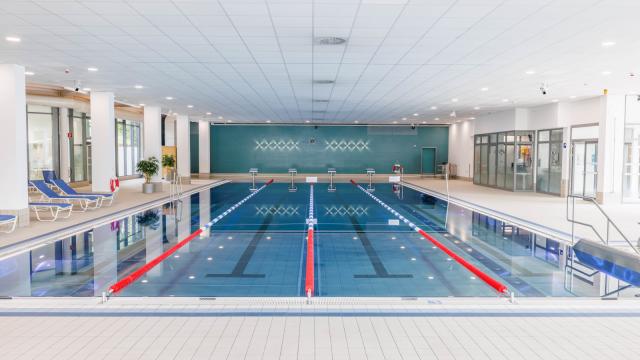 Schwimmhalle vom Kiosk aus gesehen mit 4 Schwimmbahnen, Schwimmmeisterraum und Liegen